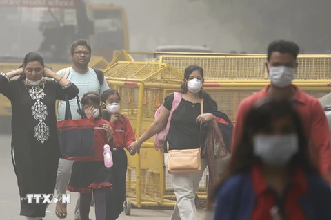 Người dân đeo khẩu trang để tránh tác hại của khói mù ô nhiễm ở New Delhi, Ấn Độ ngày 6/11. (Nguồn: AP/TTXVN) 