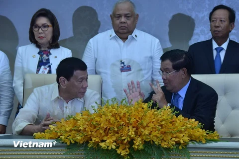 Thủ tướng Hun Sen và Tổng thống Duterte trao đổi tại lễ ký kết. (Ảnh: Nguyễn Lâm/Vietnam+)