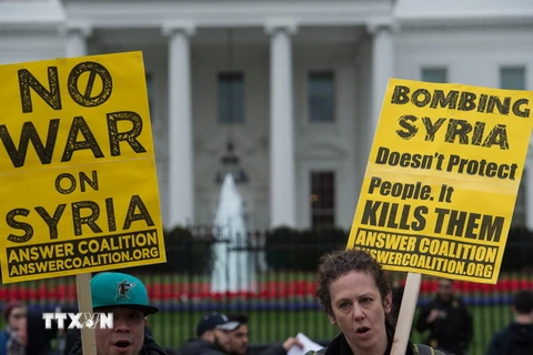 Người dân tuần hành phản đối các vụ tấn công bằng tên lửa vào Syria. (Nguồn: AFP/TTXVN)