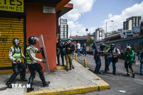 Cảnh sát Venezuela trong cuộc xung đột với người biểu tình ở Caracas ngày 4/4. (Nguồn: AFP/TTXVN) 