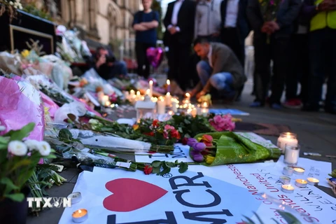 Người dân đặt hoa và thắp nến tại lễ tưởng niệm các nạn nhân vụ tấn công khủng bố ở Manchester. (Nguồn: EPA/TTXVN)
