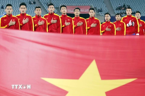 Cầu thủ đội tuyển U20 Việt Nam làm thủ tục chào cờ và hát quốc ca trước trận đấu. (Ảnh: Minh Tiến/TTXVN) 