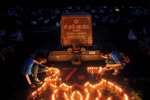 Các đoàn viên thanh niên thắp nến tri ân các Anh hùng Liệt sỹ tại Nghĩa trang Liệt sỹ TP. Hồ Chí Minh. (Ảnh: An Hiếu/TTXVN)