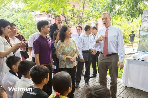 Đại sứ Mỹ, Ted Osius tới thăm và tặng những chiếc mũ bảo hiểm cho các em nhỏ tại làng SOS. (Ảnh: Tiến Đạt/Vietnam+)