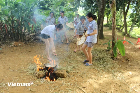 Đoàn thanh niên giao lưu Việt-Thái thử sức nấu cơm với nhiên liệu là rơm rạ. (Ảnh: CTV)
