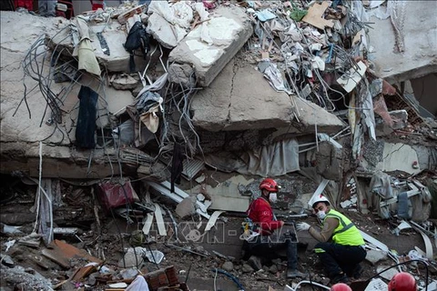 Lực lượng cứu hộ và tình nguyện viên tìm kiếm các nạn nhân dưới đống đổ nát sau động đất ở tỉnh Izmir, Thổ Nhĩ Kỳ ngày 31/10/2020. (Nguồn: AFP/TTXVN)