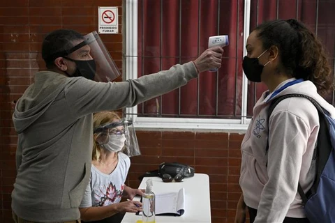 Kiểm tra thân nhiệt nhằm ngăn chặn sự lây lan của dịch COVID-19 tại Buenos Aires, Argentina. Ảnh: AFP/TTXVN