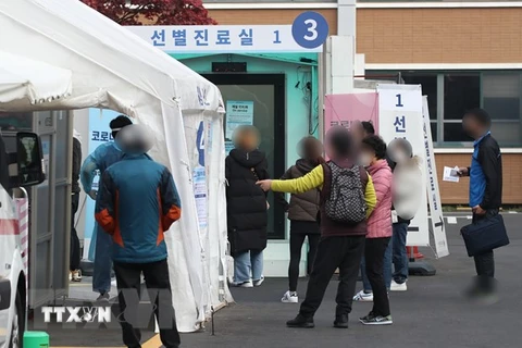 Người dân chờ lấy mẫu xét nghiệm COVID-19 tại Seoul. (Ảnh: Yonhap/TTXVN)