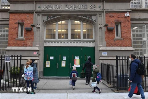 Học sinh tiểu học tới lớp trong ngày đầu tiên trường học mở cửa trở lại tại New York, Mỹ ngày 7/12/2020. Ảnh: AFP/TTXVN