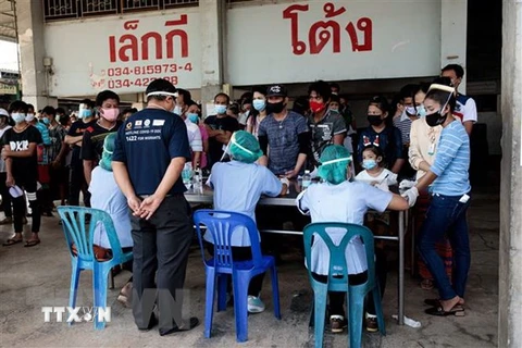 Người dân xếp hàng chờ xét nghiệm COVID-19 tại Samut Sakhon, Thái Lan. (Ảnh: AFP/TTXVN) 