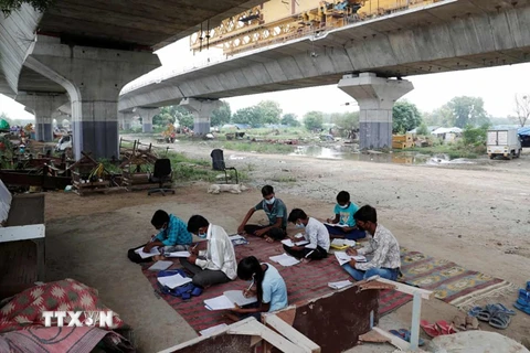 Sau khi Ấn Độ đóng cửa toàn bộ trường học từ tháng 3 vừa qua, nhiều học sinh không có điều kiện tiếp cận internet đã tham gia lớp học ngoài trời. (Ảnh: Reuters) 