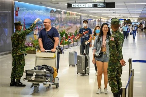 Kiểm tra thân nhiệt của hành khách nhằm ngăn chặn sự lây lan của dịch COVID-19 tại sân bay quốc tế Phuket, Thái Lan. (Ảnh: AFP/TTXVN) 