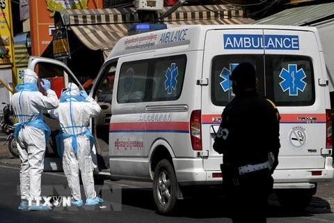 Nhân viên y tế và xe cứu thương được huy động để chuyển bệnh nhân COVID-19 tại Phnom Penh, Campuchia. (Ảnh: AFP/TTXVN)