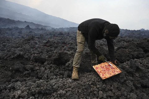 Anh David Garcia nướng pizza trên dung nham từ núi lửa Pacaya ở San Vicente Pacaya, Guatemala ngày 11/5/2021. (Ảnh: AFP/TTXVN)