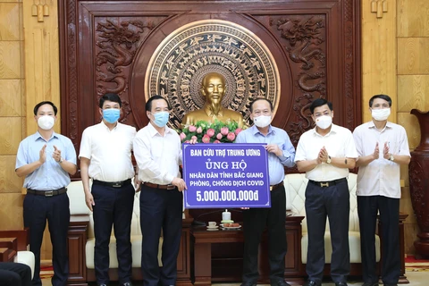 Đoàn Ủy ban Trung ương Mặt trận tổ quốc Việt Nam trao biểu trưng 5 tỷ đồng cho đại diện tỉnh Bắc Giang. (Ảnh: Danh Lam-TTXVN)