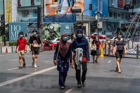 Người dân đeo khẩu trang phòng lây nhiễm COVID-19 tại Kuala Lumpur, Malaysia. (Ảnh: AFP/TTXVN) 