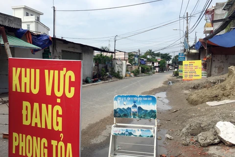 Lực lượng chức năng phong tỏa một đoạn đường TL19 (Khu phố 3B, phường Thạnh Lộc, Quận 12, Thành phố Hồ Chí Minh). (Ảnh: Tiến Lực - TTXVN)