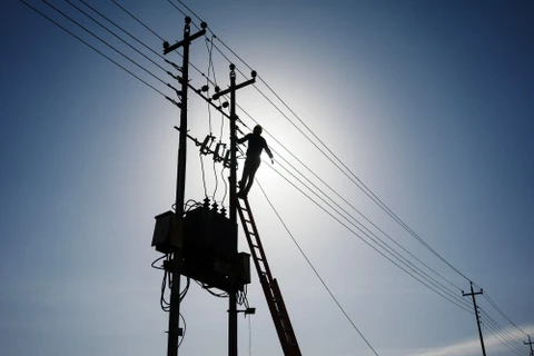 Công nhân sửa chữa đường dây tải điện tại Mosul, Iraq. (Ảnh: AFP/TTXVN)