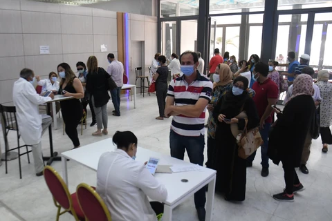 Trong ảnh: Người dân xếp hàng chờ tiêm vaccine phòng COVID-19 tại Tunis, Tunisia, ngày 26/6/2021. Ảnh: THX/ TTXVN 