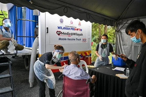 Nhân viên y tế tiêm vaccine ngừa COVID-19 cho người dân tại Kuala Lumpur (Malaysia). (Ảnh: AFP/TTXVN) 