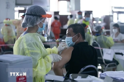Nhân viên y tế tiêm vaccine phòng COVID-19 cho người dân tại thủ đô Vientiane của Lào (Ảnh: THX/TTXVN)