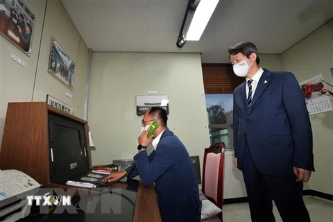 Bộ trưởng Thống nhất Hàn Quốc Lee In-young (phải) thăm phòng đặt đường dây nóng liên lạc với Triều Tiên tại làng biên giới Panmunjom ở Khu phi quân sự giữa hai miền Triều Tiên. (Ảnh: AFP/TTXVN)