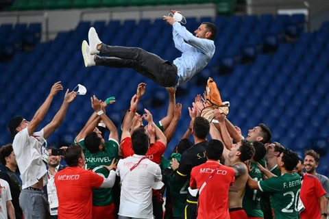 Niềm vui của các cầu thủ và huấn luyện viên Mexico sau khi giành chiến thắng trước Nhật Bản trong trận tranh HCĐ môn bóng đá nam Olympic Tokyo 2020 ngày 6/8/2021. (Ảnh: AFP/TTXVN)