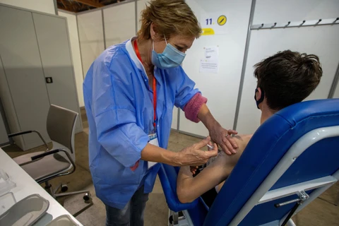 Nhân viên y tế tiêm vaccine ngừa COVID-19 cho người dân tại trung tâm tiêm chủng ở Brussels, Bỉ, ngày 26/6/2021. (Ảnh: AFP/TTXVN)