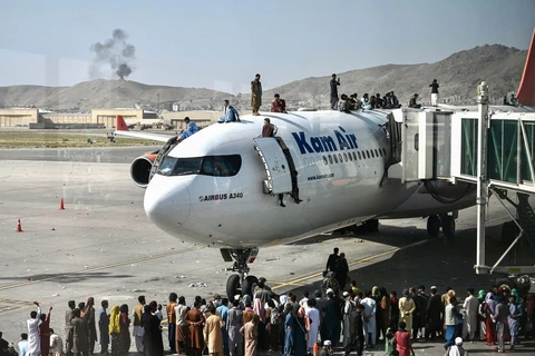 Nhiều người dân Afghanistan đã đu lên nóc máy bay để ngồi chờ được bay.(Nguồn: AFP) 