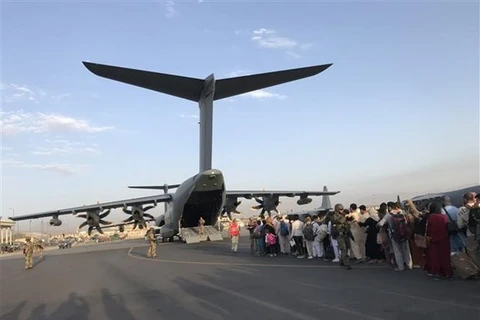 Người dân xếp hàng chờ lên máy bay quân sự để rời Afghanistan tại sân bay Kabul, ngày 24/8/2021. (Ảnh: THX/TTXVN) 