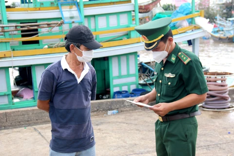 Tàu thuyền khi cập bến cảng cá Phan Thiết phải xuất trình giấy tờ theo quy định cho lực lượng chức năng. (Ảnh: Nguyễn Thanh/TTXVN)