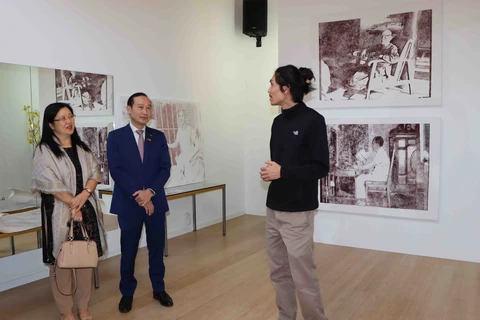 Họa sĩ Thy Nguyên giới thiệu tranh với Đại sứ Việt Nam tại Vương quốc Bỉ Nguyễn Văn Thảo và phu nhân. (Ảnh: Hương Giang/ TTXVN)
