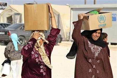 Người tị nạn Syria tại trại tị nạn Zaatari, thành phố Mafraq, Jordan, giáp biên giới Syria nhận hàng viện trợ của Liên hợp quốc ngày 22/10/2012. (Ảnh: Reuters.)