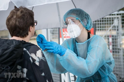 Nhân viên y tế lấy mẫu xét nghiệm COVID-19 tại Berlin, Đức. (Ảnh: AFP/TTXVN) 
