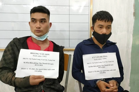 Hai đối tượng Hoàng Văn Son và Lý Văn Hưởng bị bắt giữ vì hành vi tổ chức đưa đón người vượt biên trái phép. (Ảnh: TTXVN phát)