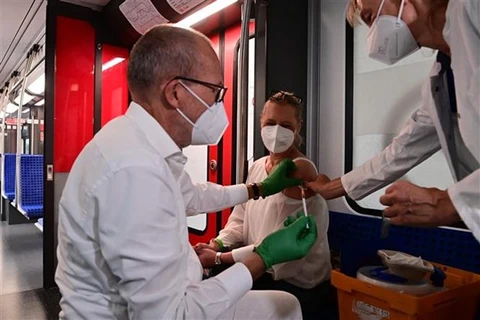 Nhân viên y tế tiêm vaccine ngừa COVID-19 cho người dân tại Berlin (Đức). (Ảnh: AFP/TTXVN) 