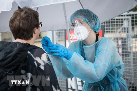 Nhân viên y tế lấy mẫu xét nghiệm COVID-19 cho người dân tại Kreuzberg, Berlin, Đức. (Ảnh: AFP/TTXVN)