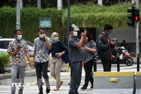 Người dân đeo khẩu trang phòng lây nhiễm COVID-19 tại Jakarta, Indonesia. (Ảnh: THX/TTXVN) 