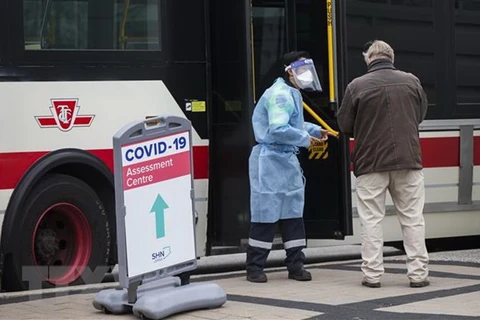 Nhân viên y tế hướng dẫn người dân tại một điểm xét nghiệm COVID-19 ở Toronto, Ontario, Canada. (Ảnh: THX/TTXVN) 