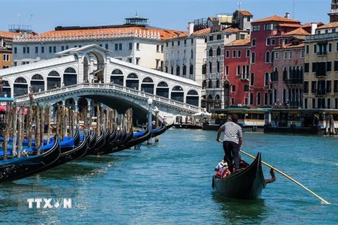 Khách du lịch đi thuyền gondola tại Venice, Ital. (Ảnh: AFP/ TTXVN)