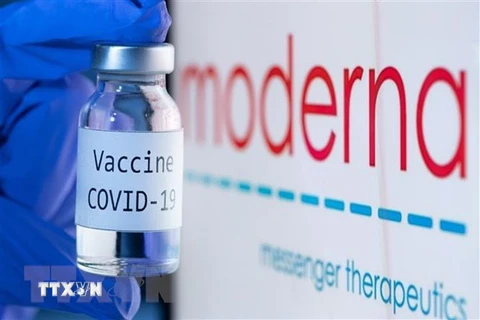 Vaccine ngừa COVID-19 bên biểu tượng của Hãng dược phẩm Moderna. (Ảnh: AFP/TTXVN)