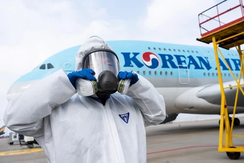 Nhân viên chuẩn bị phun thuốc khử trùng trên máy bay của Korean Air nhằm ngăn chặn sự lây lan của dịch COVID-19 tại sân bay quốc tế Incheon, Hàn Quốc. (Ảnh: AFP/TTXVN)