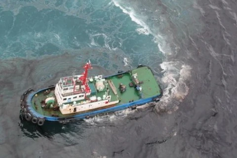 Tàu phun chất phân tán dầu lên vết dầu loang trên biển - (Ảnh: Bangkok Post)