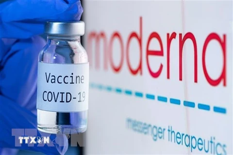 Vaccine ngừa COVID-19 bên biểu tượng của Hãng dược phẩm Moderna. (Ảnh: AFP/TTXVN) 