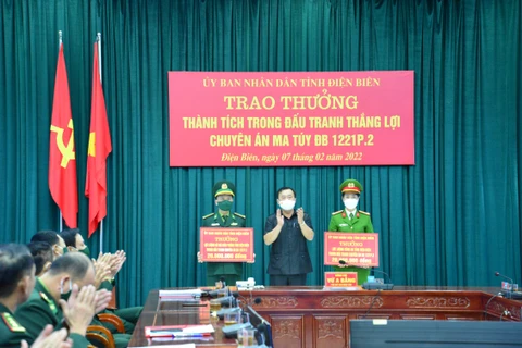Phó Chủ tịch UBND tỉnh Điện Biên Vừ A Bằng trao Bằng khen của UBND tỉnh Điện Biên cho các lực lượng tham gia phá án. (Ảnh: TTXVN)