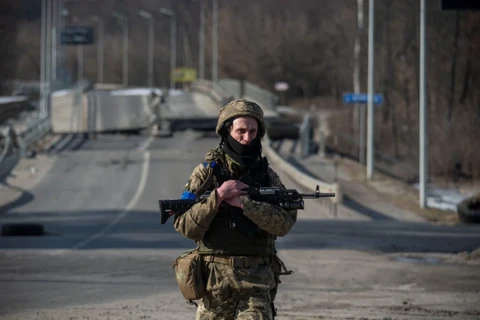 Một binh sỹ Ukraine đứng trước cây cầu bị phá hủy ở vùng Sumy hôm 19/3. (Ảnh: Reuters.)