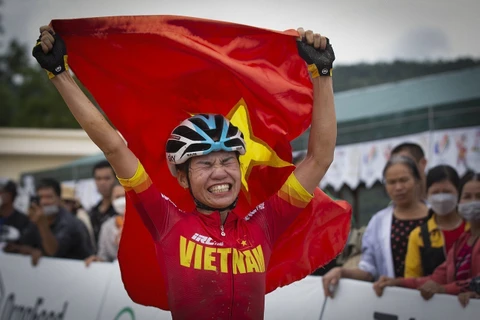 Khoảnh khắc hạnh phúc của VĐV Đinh Thị Như Quỳnh khi cô giơ cao lá cờ Tổ quốc.(Ảnh: Trọng Đạt/TTXVN)