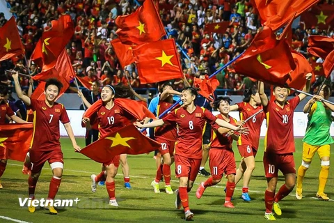 Đội tuyển nữ Việt Nam cầm quốc kỳ, chạy quanh sân vận động Cẩm Phả ăn mừng cùng với hơn 16.000 khán giả trên khán đài. (Ảnh: PV/Vietnam+)