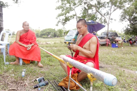 Sư thầy Bounpon Tathammo đang quấn lại miếng vải trên que dùng để nhồi thuốc cho quả Bangphay tại lễ cầu mưa tại bản Naxone, thủ đô Viêng Chăn. (Ảnh: Phạm Kiên/TTXVN)