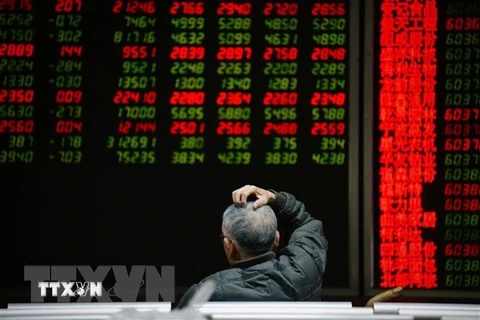 Nhà đầu tư theo dõi bảng chỉ số chứng khoán tại Bắc Kinh, Trung Quốc. (Ảnh: AFP/TTXVN) 